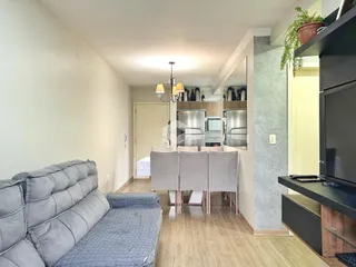 Sala de estar com sofá e área de jantar em um apartamento.