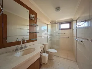 Foto de um banheiro com azulejos brancos e bancada de mármore.