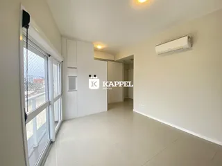 Sala de estar com grandes janelas e piso de cerâmica clara.