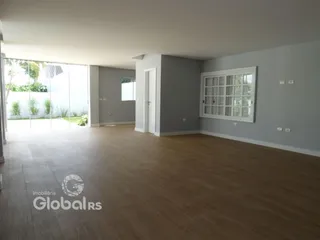 Sala de estar ampla com piso de madeira e porta de vidro que dá para o exterior.