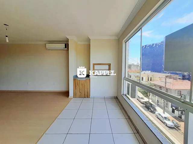 Sala de estar com piso de madeira e vista urbana através da janela.