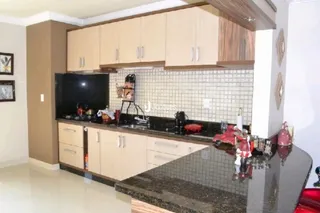 Foto de uma cozinha com armários de madeira e revestimento de azulejos.