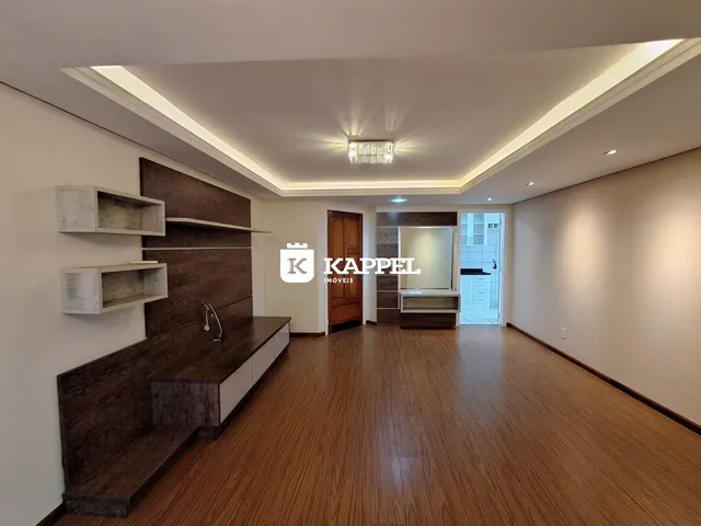Sala de estar com piso de madeira e painel decorativo.