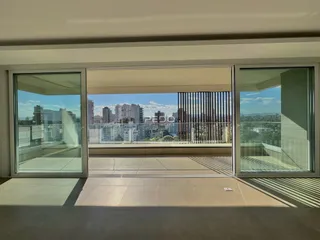 Vista da sala de estar com portas de vidro que dão para uma área externa.