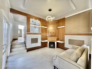 Sala de estar com painéis de madeira e lareira em imóvel no Brasil.