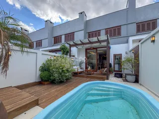 Vista externa de uma casa com piscina e deck de madeira em Lajeado.
