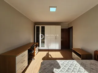 Quarto com piso de madeira e armários embutidos.