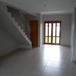 Hall de entrada com escada e piso claro.
