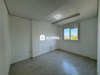 Uma sala de estar clara com piso de madeira e janela.