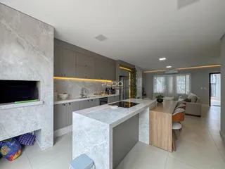 Ambiente moderno de sala e cozinha com lareira em Lajeado.