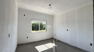 Foto de um cômodo vazio com paredes brancas e piso de concreto.