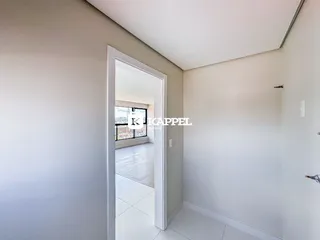 Hall de entrada com paredes brancas e piso claro.