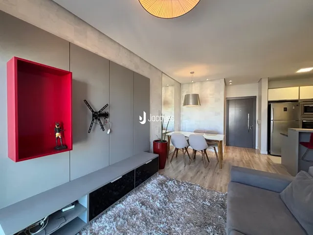 Ambiente moderno com piso de madeira e móveis planejados em um apartamento.