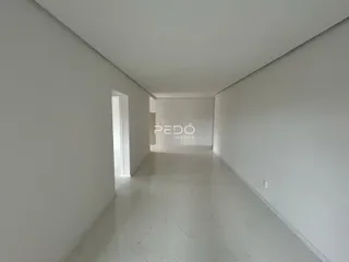 Corredor interno de uma residência com paredes brancas e piso claro.