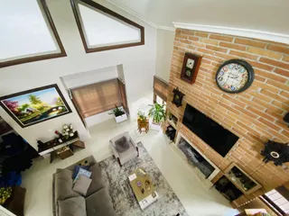 Sala de estar com parede de tijolos aparentes e lareira.