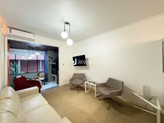 Sala de estar com sofá e decoração clara em um apartamento.
