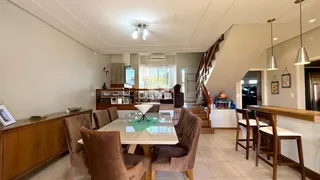 Sala de jantar com mesa e cadeiras em ambiente interno.