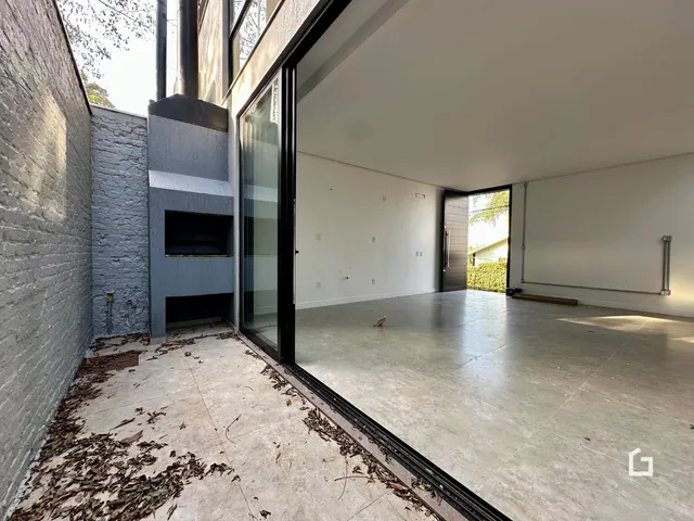 Vista de um ambiente interno com piso de concreto e porta de vidro.