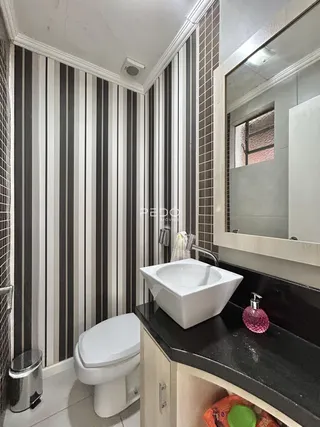 Foto de um banheiro com revestimento de azulejos e bancada escura.