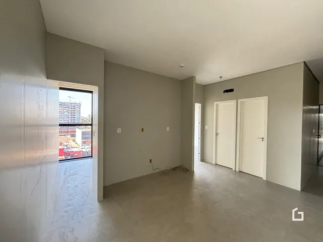 A foto mostra um corredor interno com portas brancas.