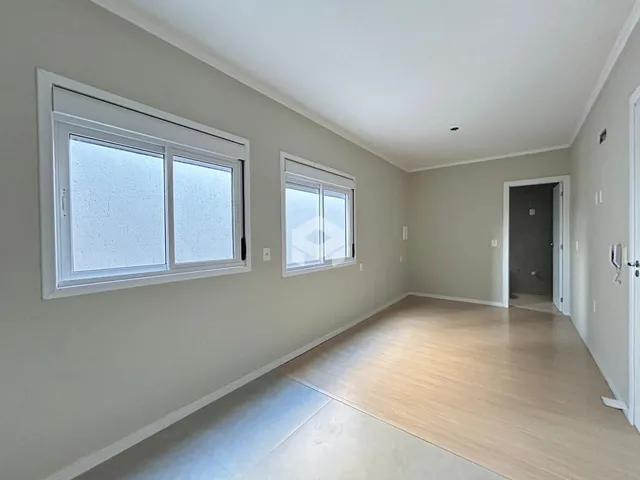 Espaço interno com paredes claras e piso de madeira.