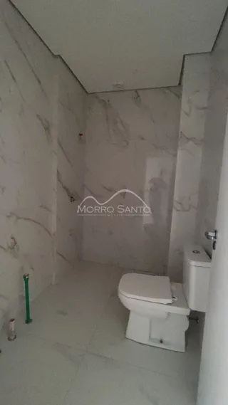 Foto de um banheiro com revestimento em mármore branco.