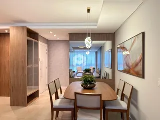 Vista de uma sala de jantar com mesa de madeira e cadeiras em um imóvel no Brasil.