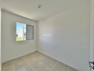Interior de uma sala com piso de cerâmica e janela.
