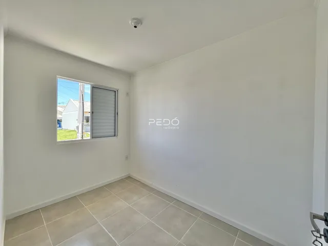 Interior de uma sala com piso de cerâmica e janela.