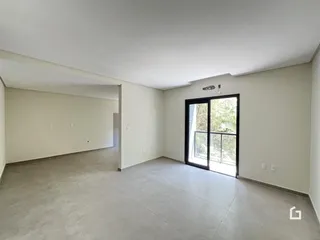 Foto de um ambiente interno amplo com paredes brancas e piso cinza.