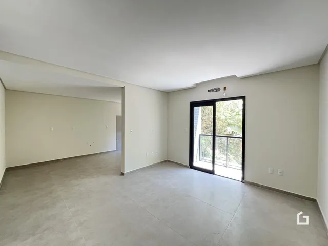 Foto de um ambiente interno amplo com paredes brancas e piso cinza.