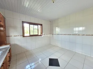 Interior de uma sala com piso de cerâmica e paredes brancas.