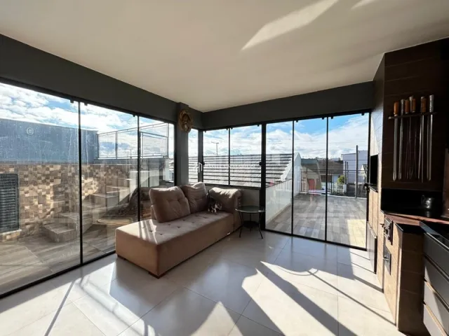 Sala de estar com grandes portas de vidro que dão vista para o exterior.