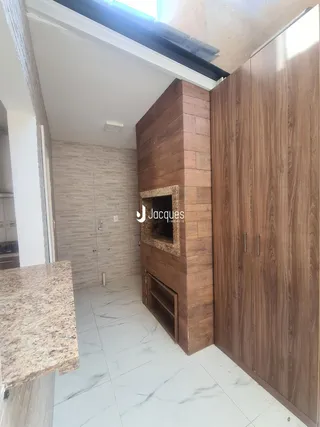 Interior de um ambiente com revestimento de madeira e piso de mármore branco.