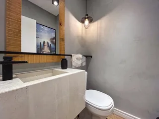 Banheiro com bancada e vaso sanitário em ambiente interno.