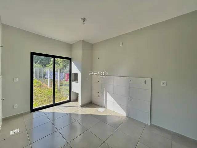 Interior de uma sala com porta de vidro abrindo para o exterior.