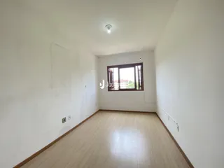 Vista interna de uma sala com piso de madeira clara.