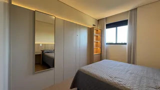 Quarto com cama e armários em um ambiente claro com iluminação natural.