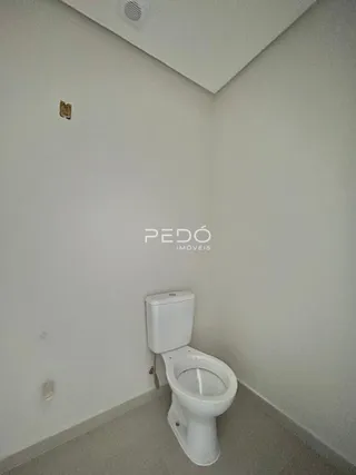 Foto de um banheiro interno com vaso sanitário branco e paredes brancas.