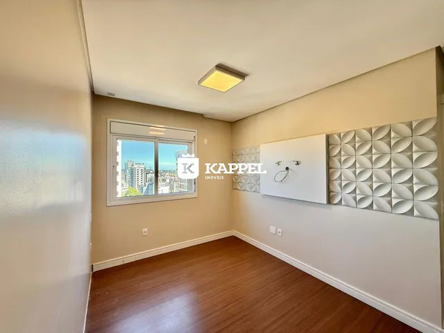 Uma sala de estar com piso de madeira e janela para a cidade.