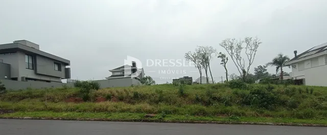 vista da fachada de uma residência em Lajeado, Brasil, com vegetação na frente.