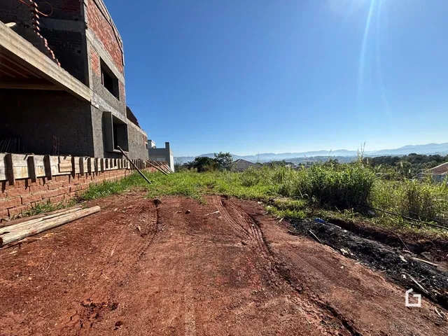 Vista externa de uma propriedade com vegetação e terra no primeiro plano.