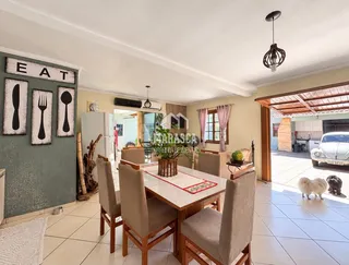 Uma sala de jantar com mesa e cadeiras em um imóvel no Brasil.