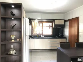 Imagem de uma cozinha com armários e janela em um imóvel no Brasil.