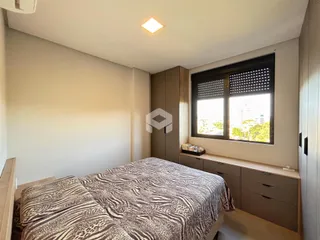 Quarto com cama e armário em um ambiente claro.