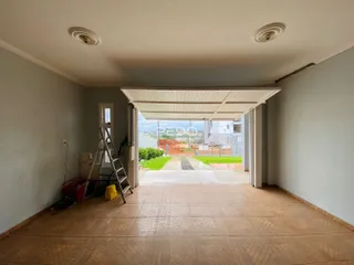 Interior com piso de cerâmica e acesso a uma área externa através de uma abertura.