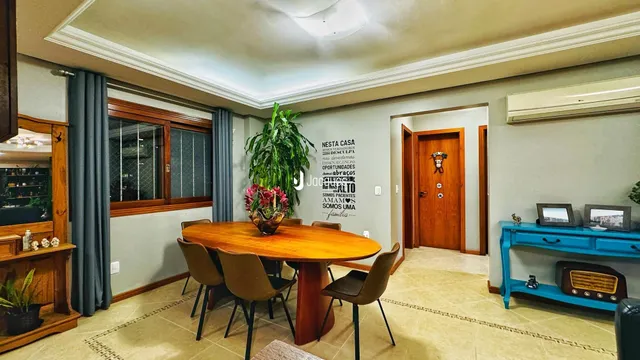 Uma sala de jantar com mesa de madeira e cadeiras é visível no interior da propriedade.