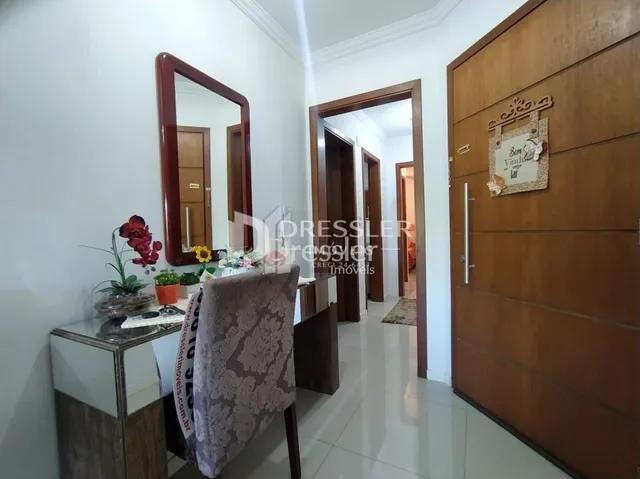 Hall de entrada com portas de madeira e espelho em um imóvel no Brasil.