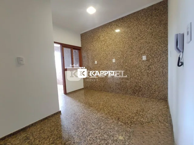Hall de entrada com piso de granito e parede texturizada.