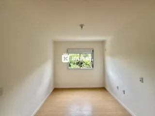 Uma foto de um cômodo interno com piso de madeira clara e uma janela.